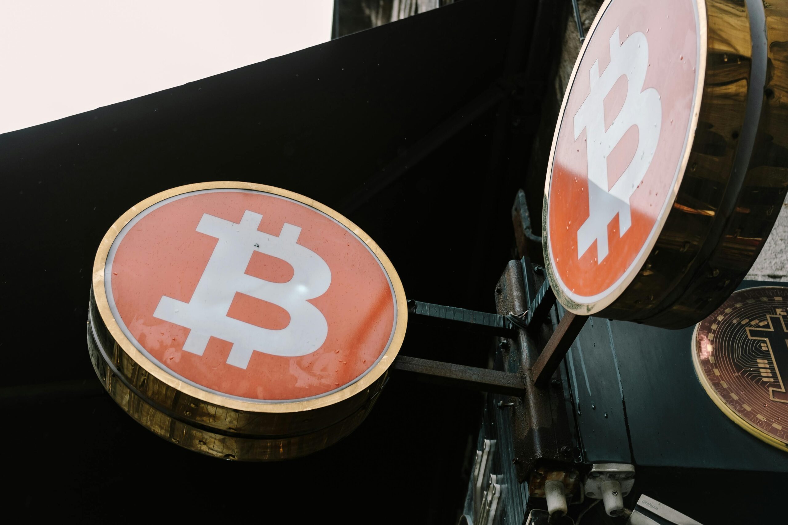 Online Geld verdienen: Soforthilfe-Programme und Ideen 2 Nahaufnahme von Bitcoin-Symbolschildern im Freien, die moderne Kryptowährungstrends widerspiegeln.