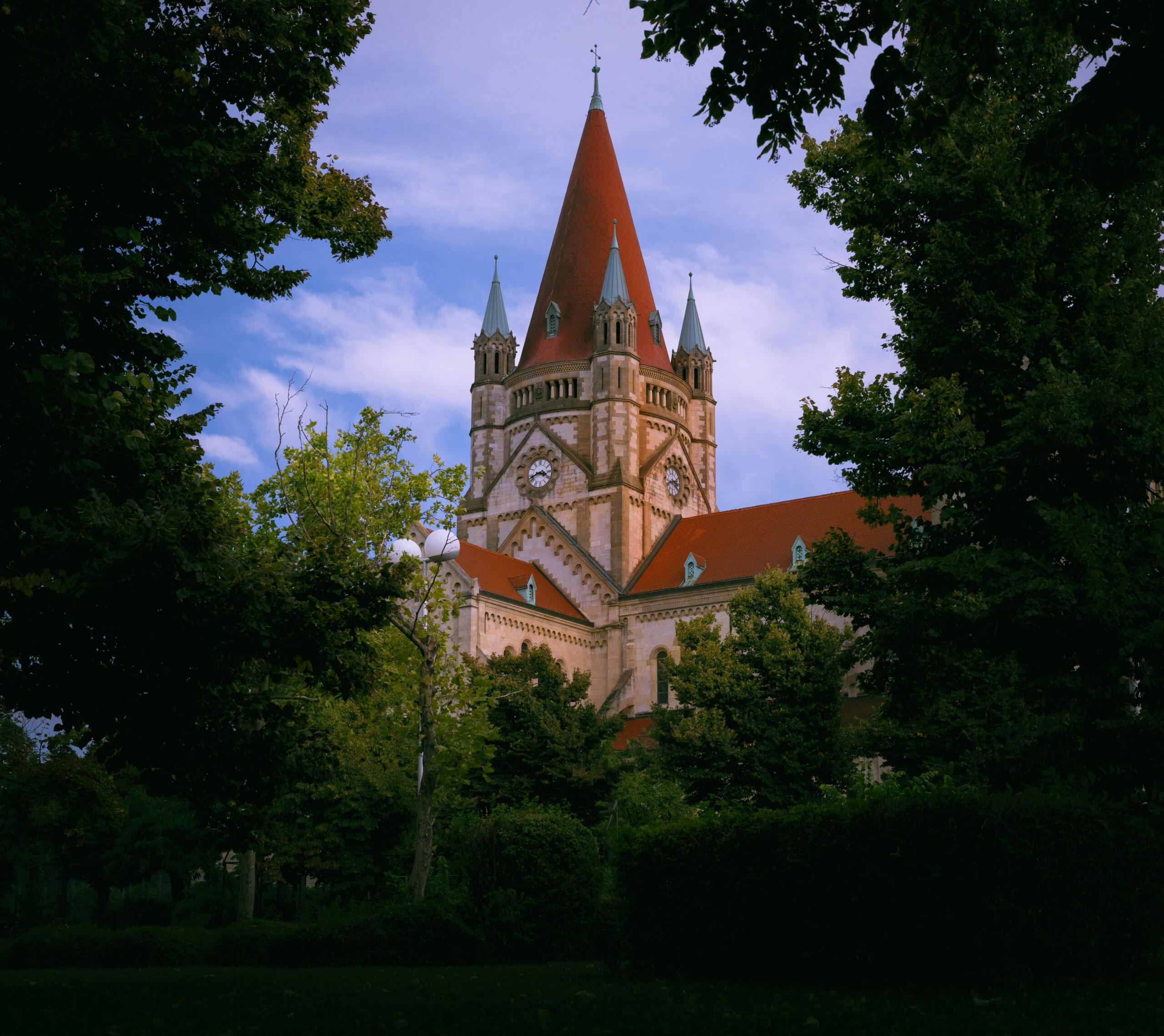 Affiliarena (Niels Wagner) im Test: Erfahrungen & Tipps 2 Wunderschöne Aufnahme der Franz-von-Assisi-Kirche in Wien, umrahmt von üppigem Grün.