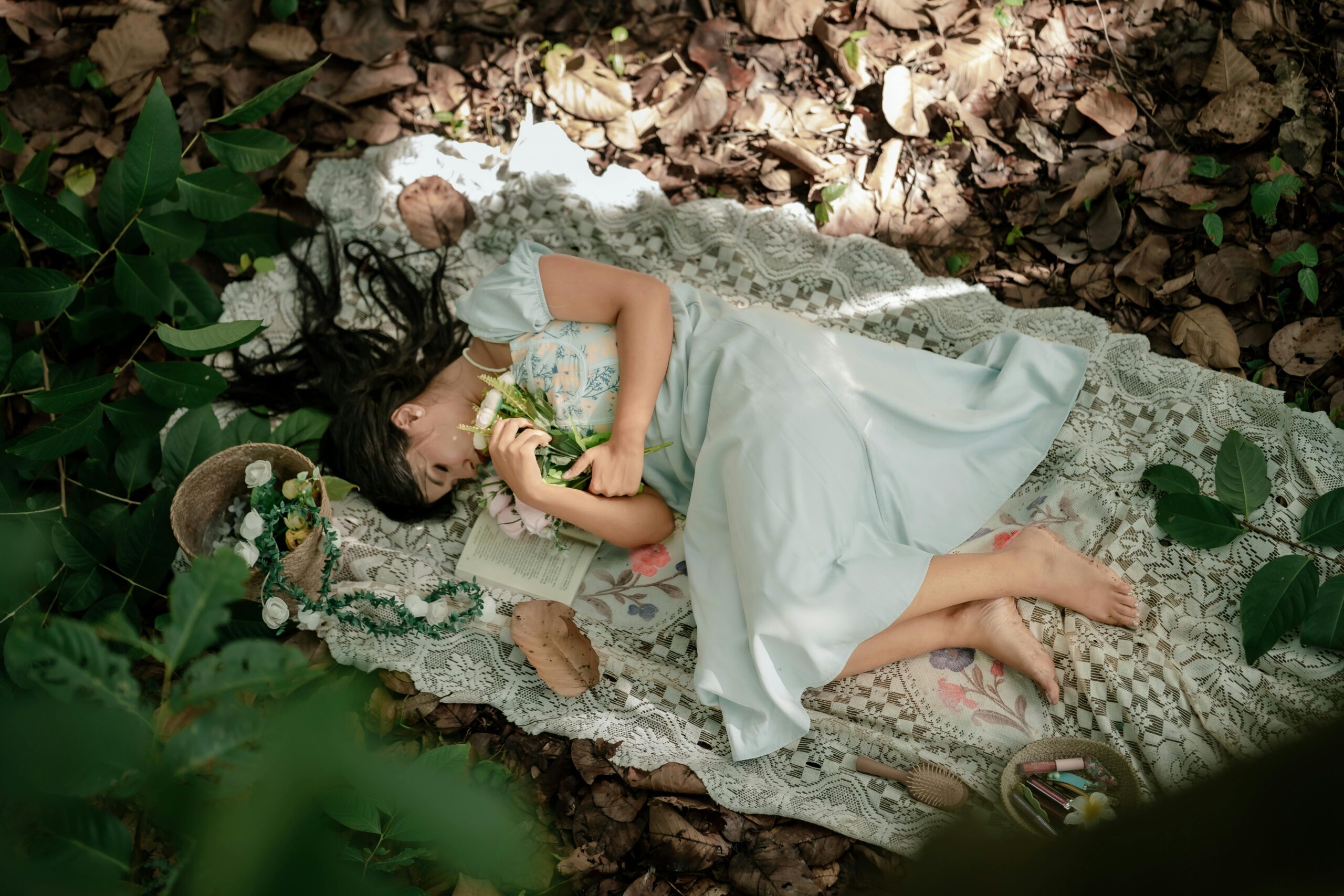 Millionen mit einem Webinar: Systematisch skalieren 2 Ein junges Mädchen ruht auf einer Picknickdecke aus Spitze, umgeben von Natur, und hält Blumen in den Händen.